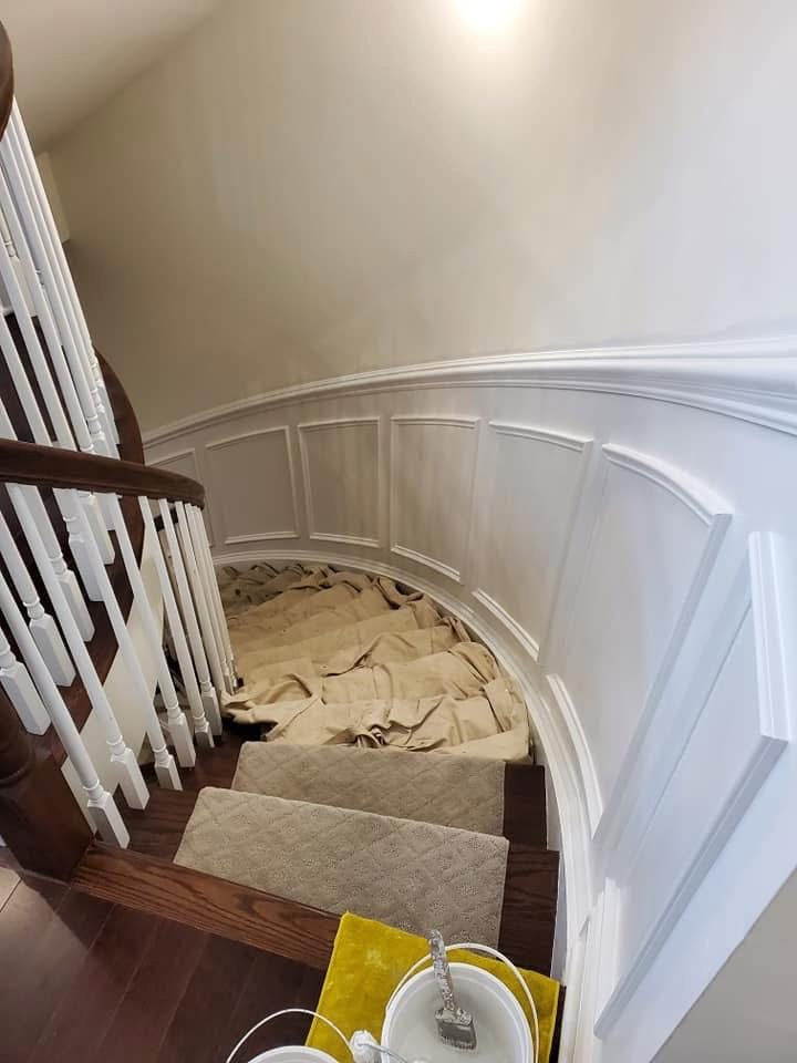 Curved staircase with white wainscoting